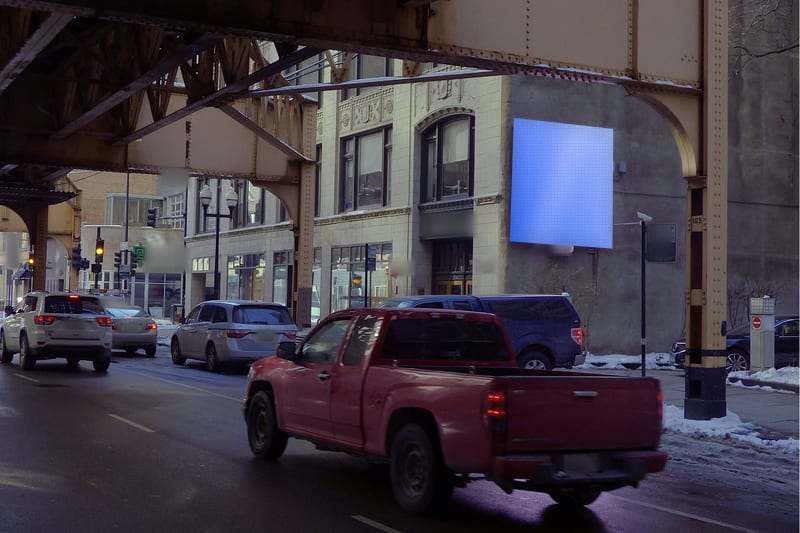 Compact digital screen at Wells St at Van Buren St · the Loop, photographed by day; the advertiser's content is replaced with a preview of your brand
